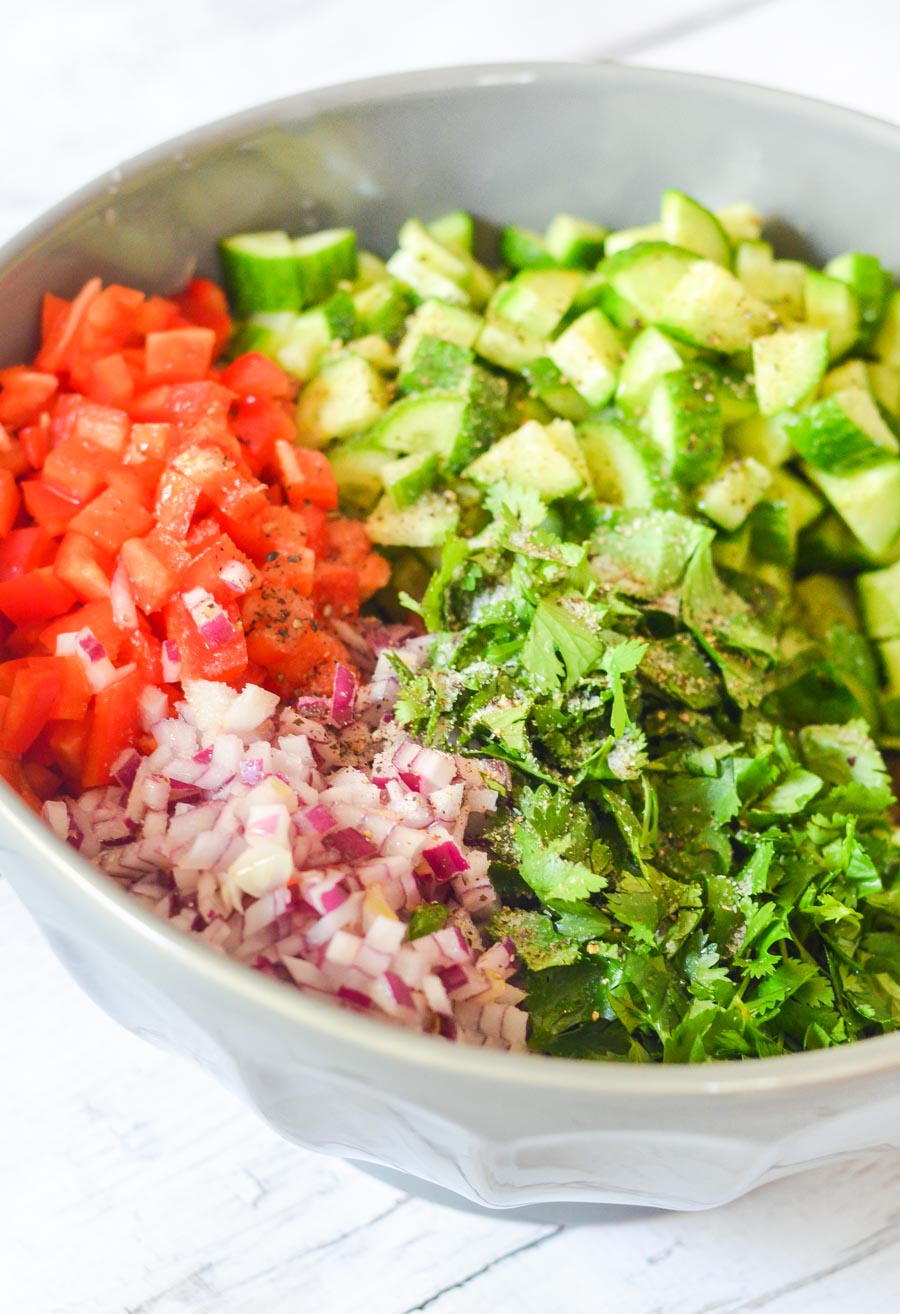 Cucumber, Red Pepper, Cilantro + Onion chopped into a mixing bowl - unmixed