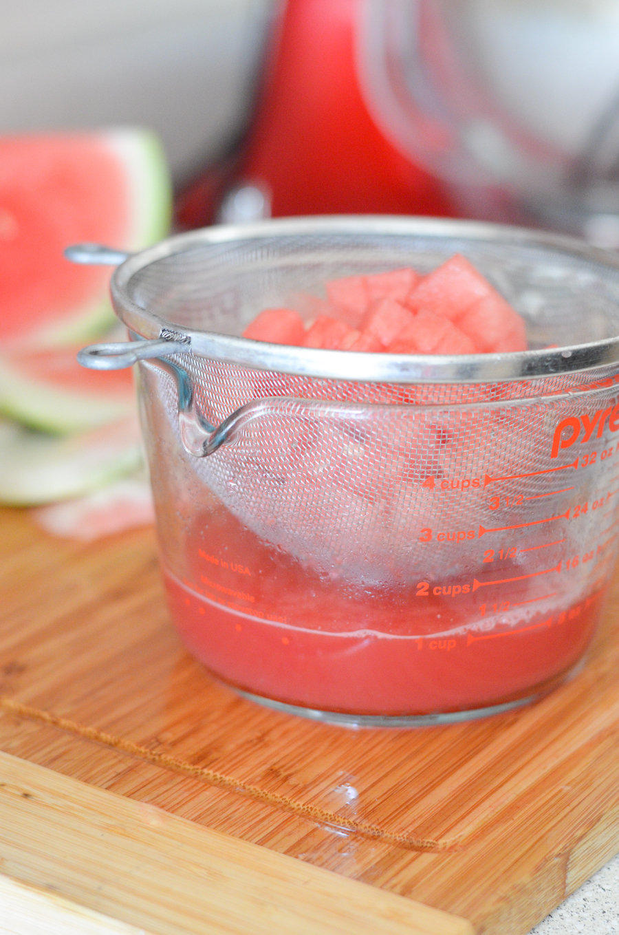 cut watermelon in sieve with watermelon juice below