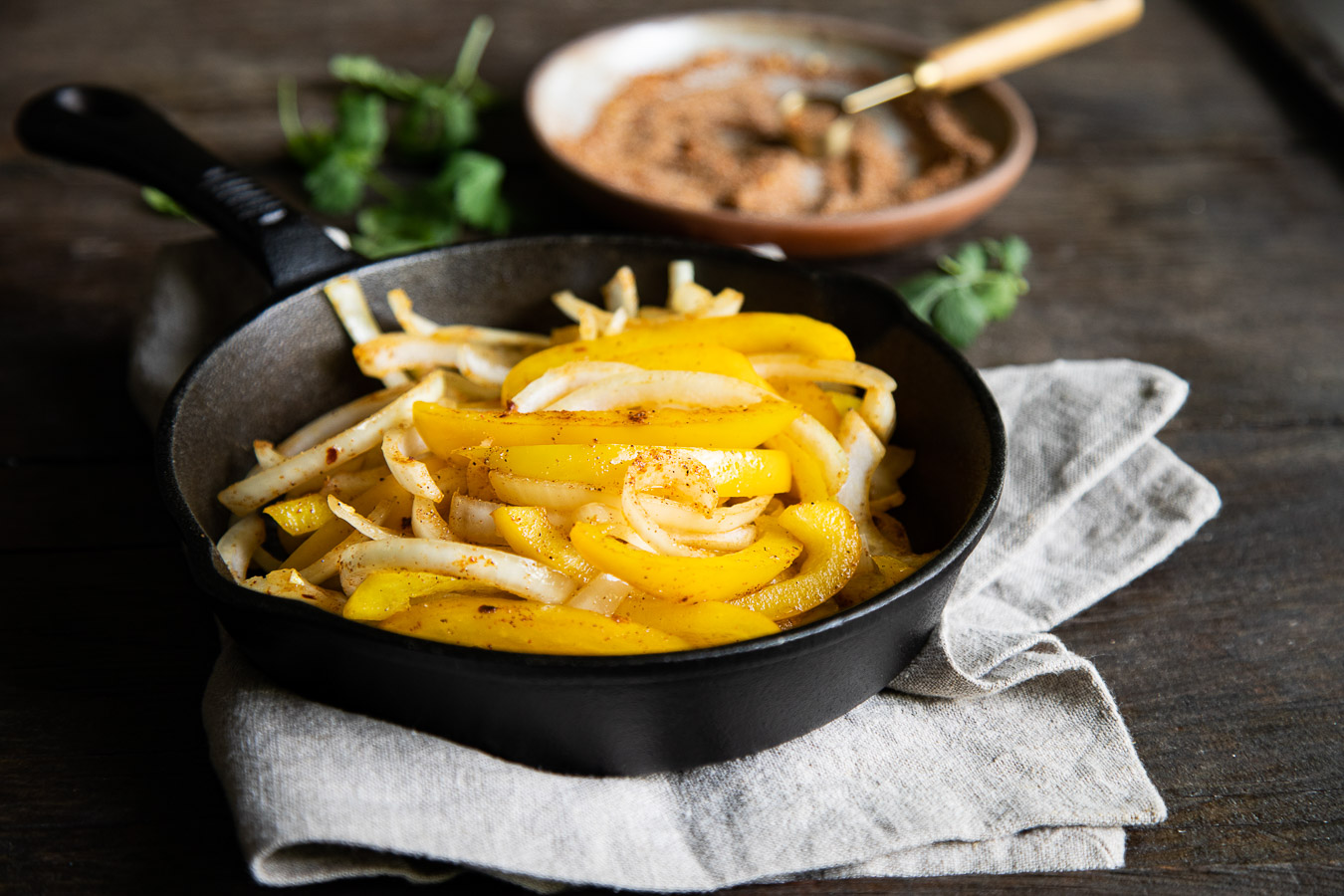 fajita veggies and seasoning in cast iron pan