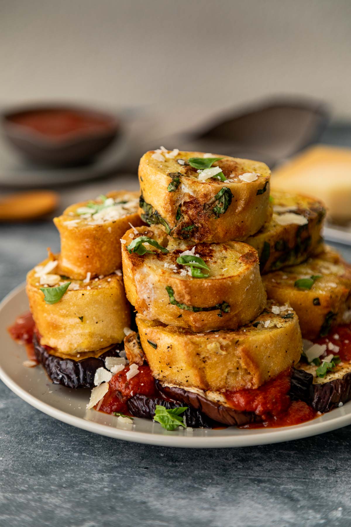 Savory French Toast Piled on Plate atop roasted eggplant slices and marinara sauce