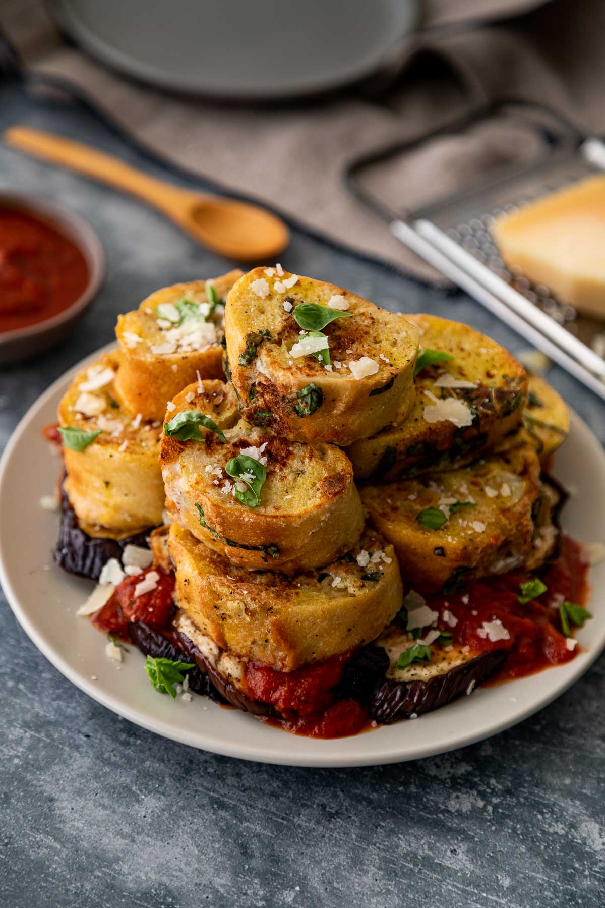 Savory French Toast Piled on Plate atop roasted eggplant slices and marinara sauce