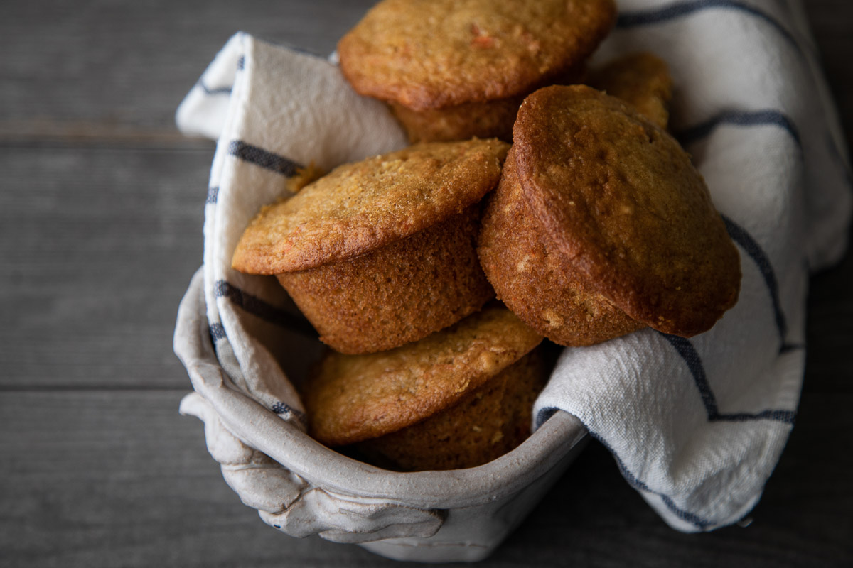 Healthy orange muffins in towel lined basket