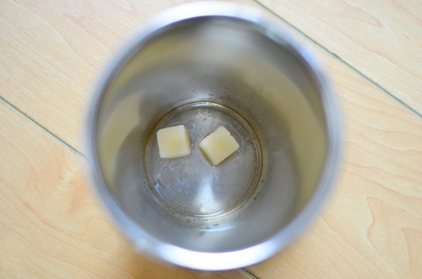 Sugar cubes and water in bottom of cocktail shaker