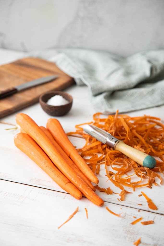 raw peeled carrots om countertop