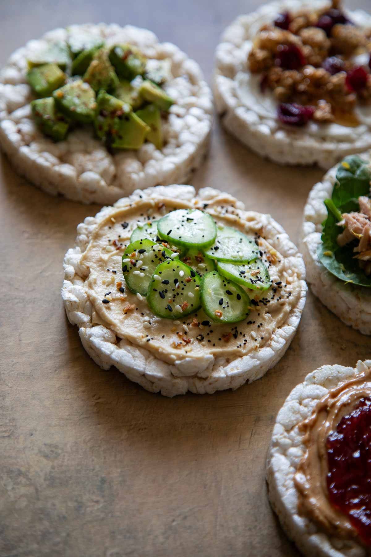 Rice Cake Toppings - 5 rice cakes on table with a variety of toppings