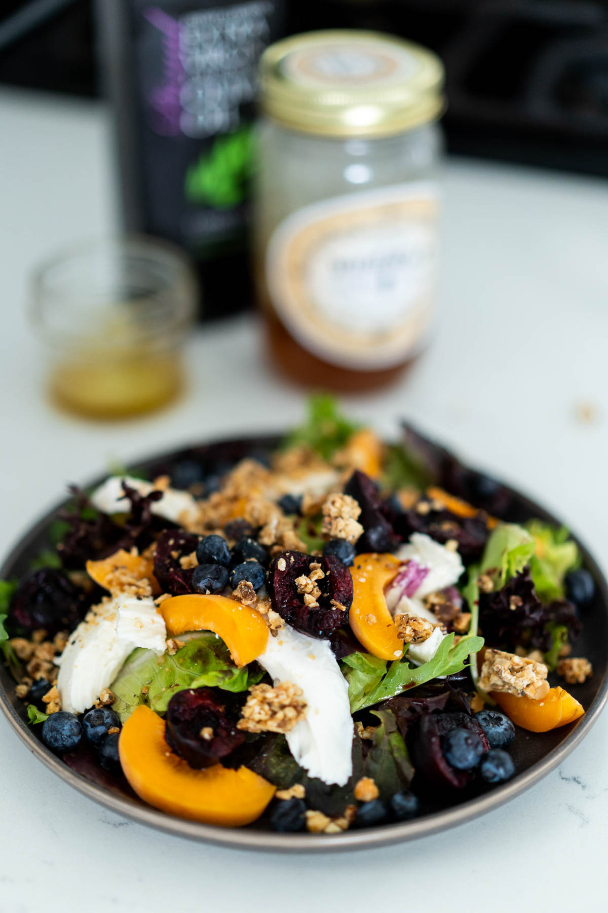 Breakfast Salad - Fruit Green Salad with jars of honey and olive oil in background