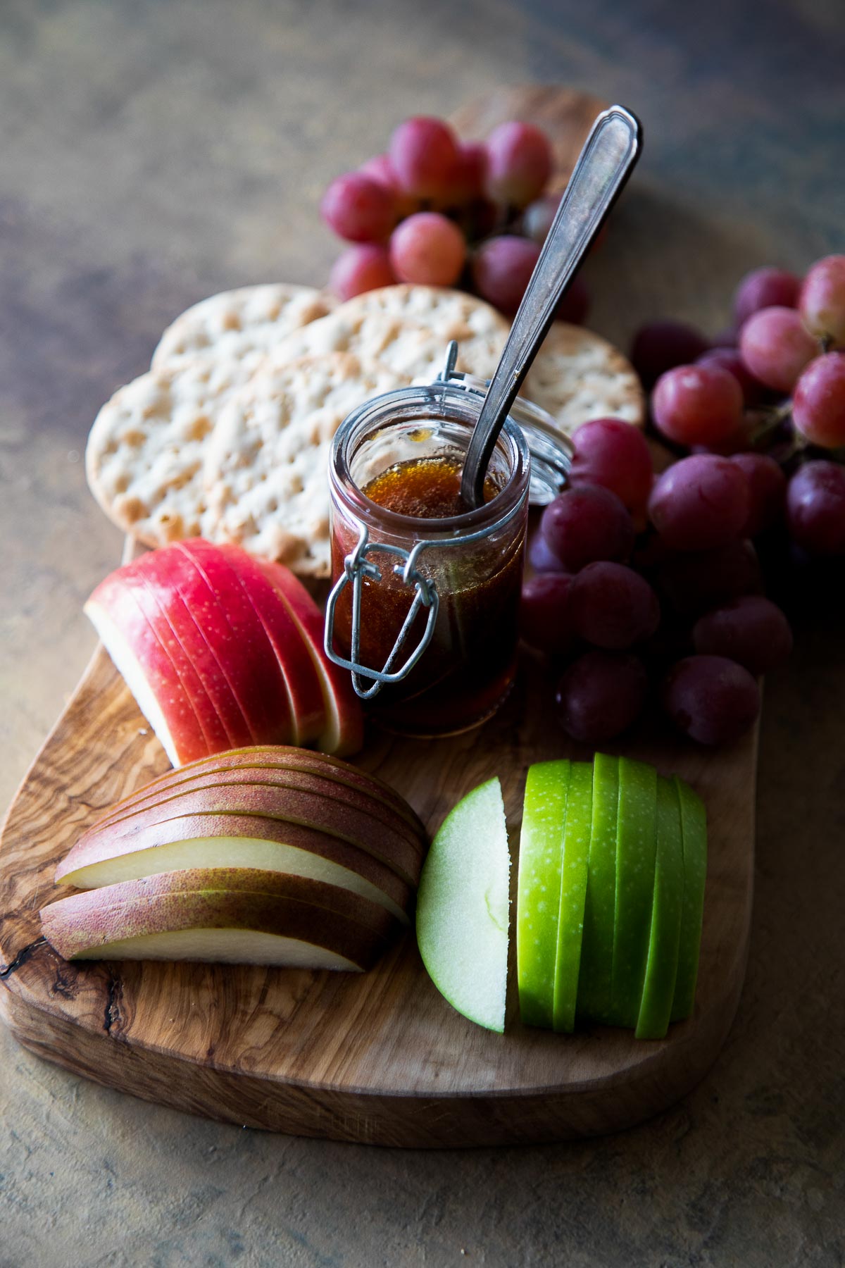 Fruit Appetizer Board with sliced pears, apples, persimmons, crackers and honey