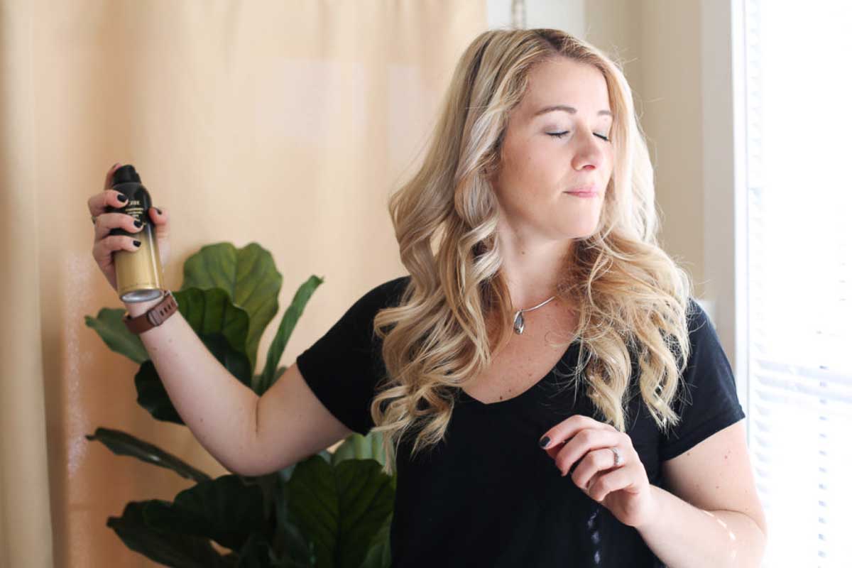 Best Anti-Frizz Spray - Oribe Anti Humidity Spray Review. Blonde woman with spray.