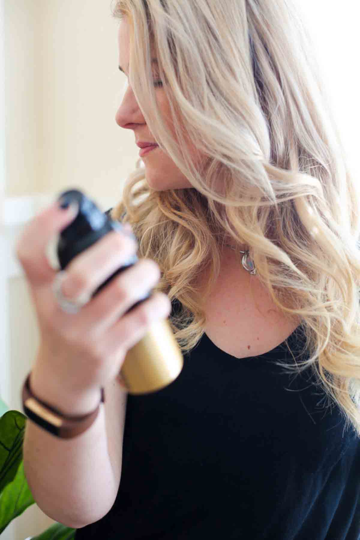 Best Anti-Frizz Spray - Oribe Anti Humidity Spray Review. Blonde woman with spray.