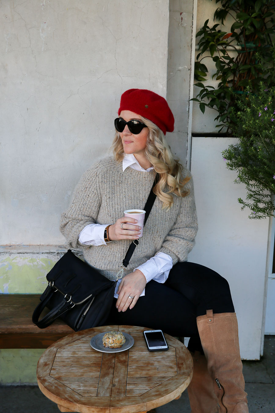 Luci sitting at cafe with cappuccino in hand