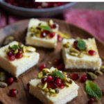 Christmas Cheesecake Bars. Gingersnap cookie crust with creamy cheesecake. Topped with red and green pomegranate arils, chopped pistachios, and mint leaves.