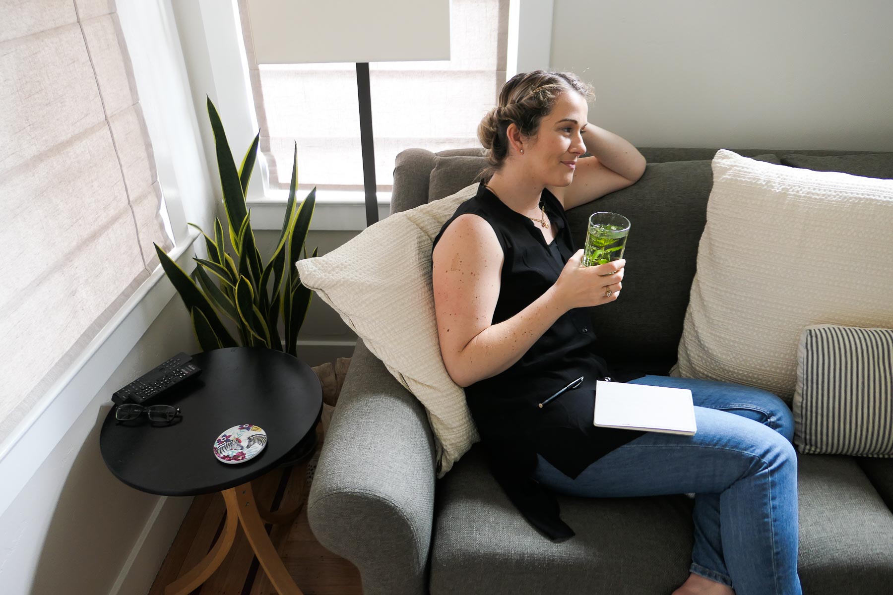 Woman drinking fresh peppermint tea in Eileen Fisher Black Tank and Everlane Jeans.