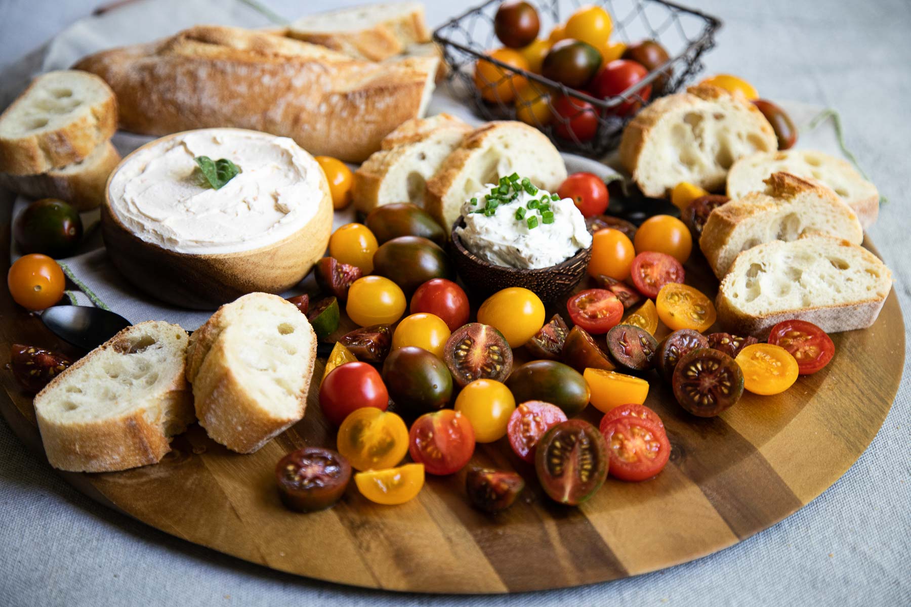 cherry tomato appetizer board - cherry tomatoes (whole and half) on striped wood board