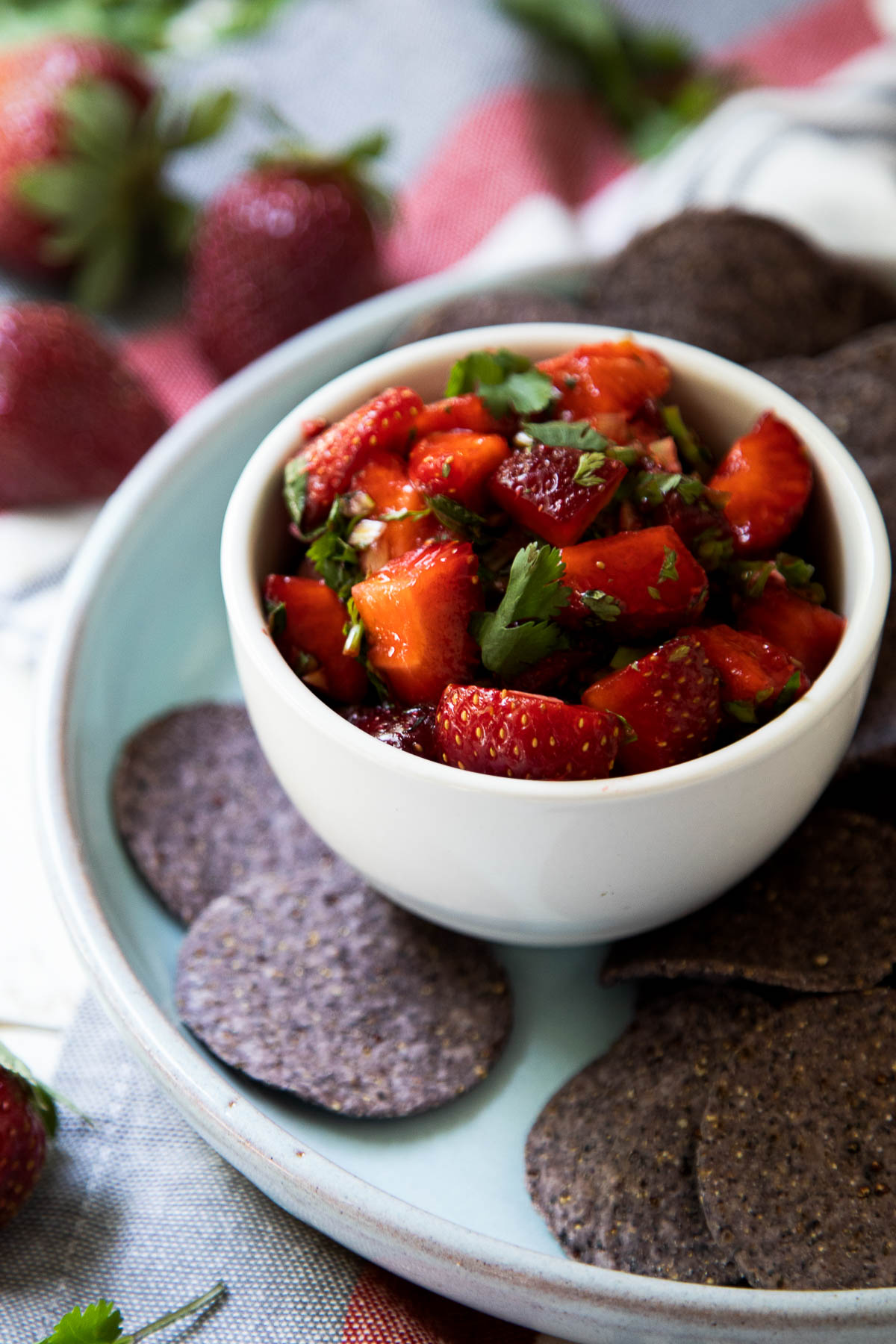 Cilantro Strawberry Salsa in White Bowl with Blue Corn Tortilla Chip Rounds