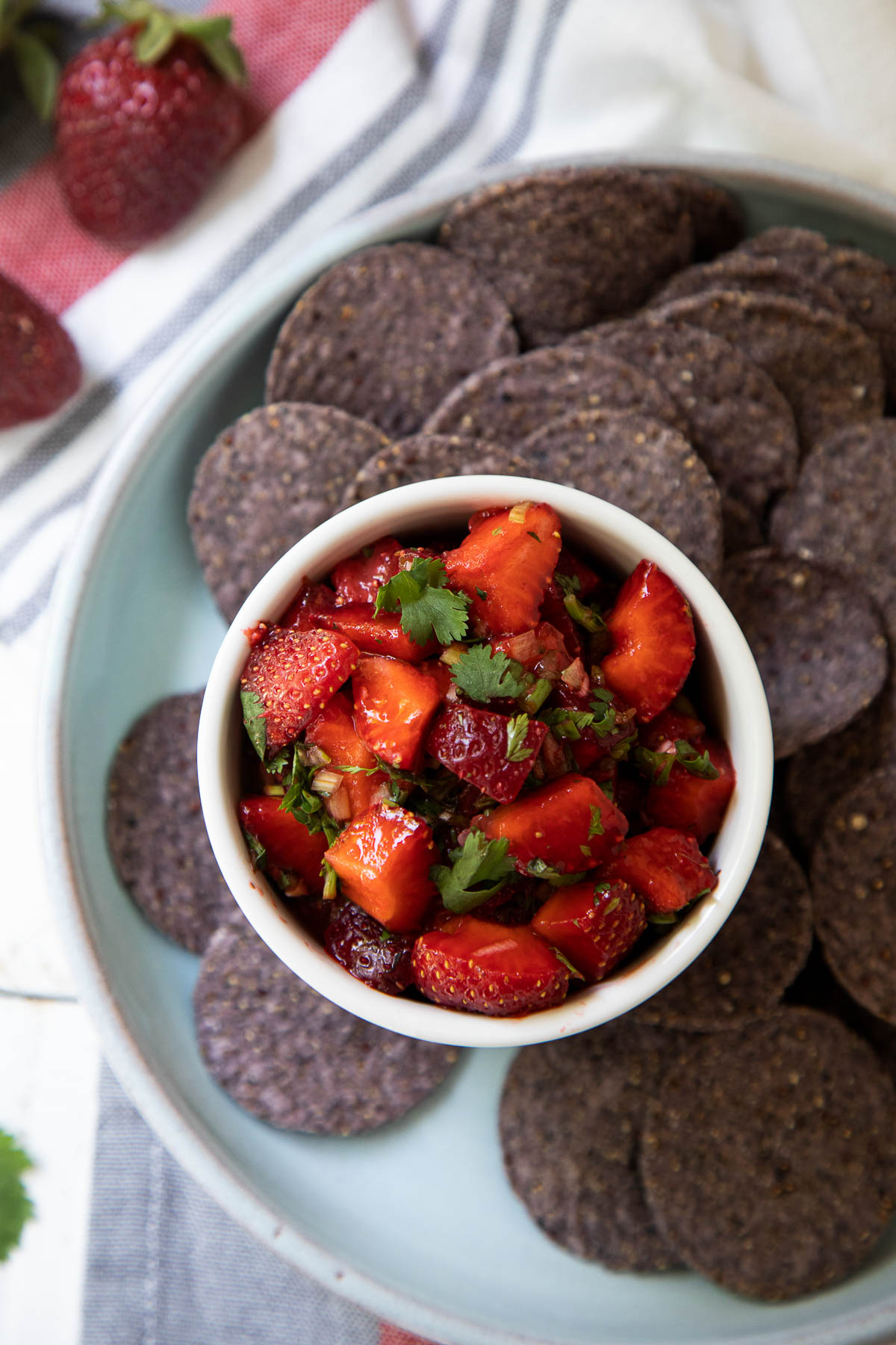 Cilantro Strawberry Salsa in White Bowl with Blue Corn Tortilla Chip Rounds - Top Down