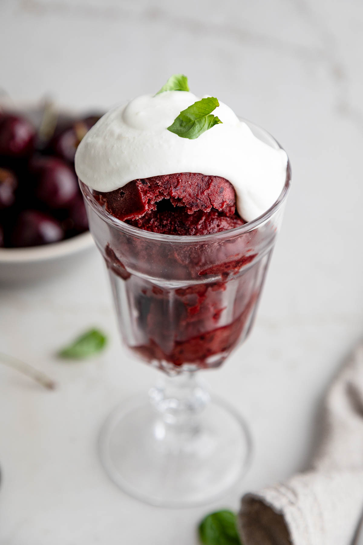 Cherry Sorbet in goblet with basil whipped cream and mint leaf - Dairy Free Sorbet