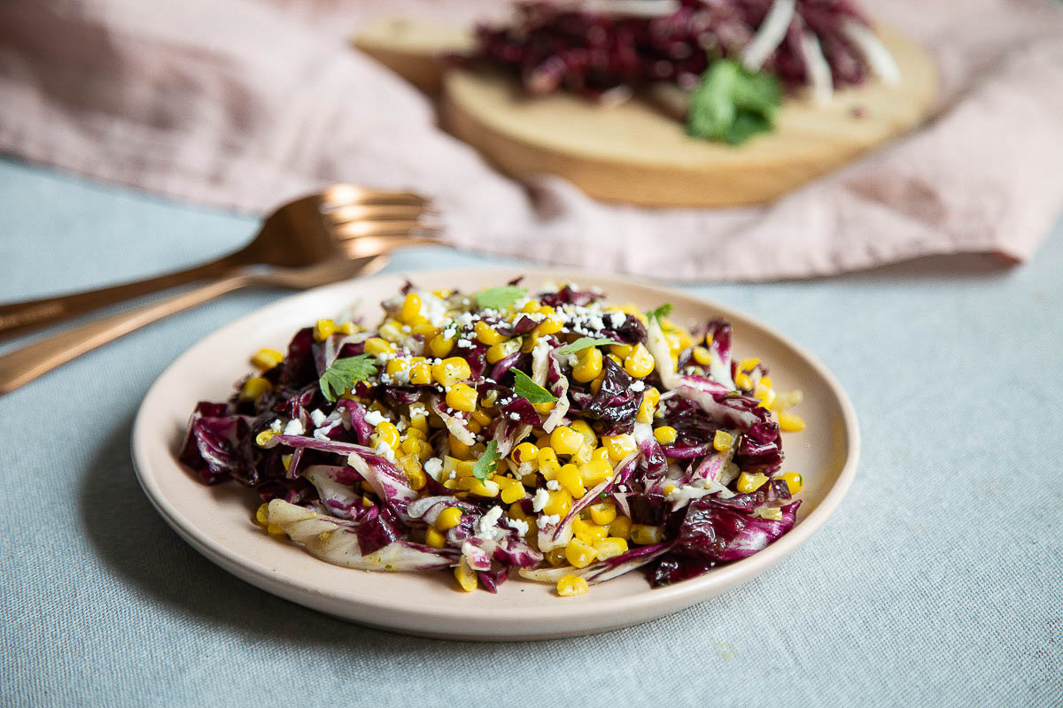 Simpel radicchio Salad with Corn on Light Pink Plate