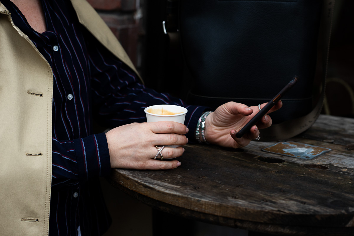 Luci on Her Phone, holding Coffee Cup