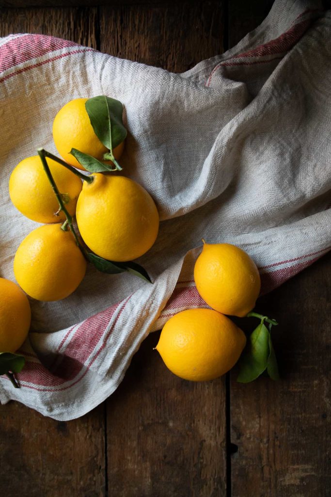 lemons on tea towel on wood table - - fall and winter appetizers