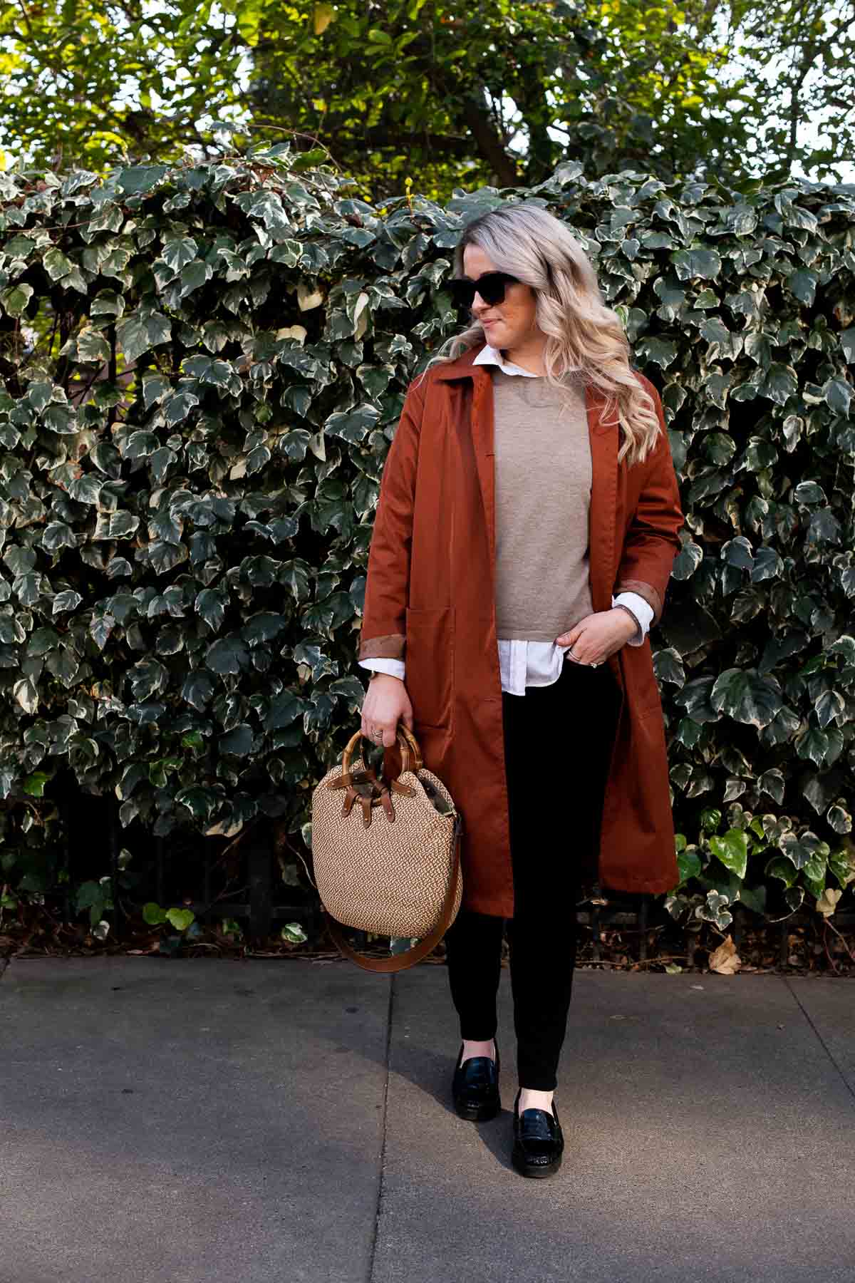 Late Winter Outfit - White Button Down Shirt under Tan Sweater with black skinny jeans, burnt orange brown coat and straw tote bag. 