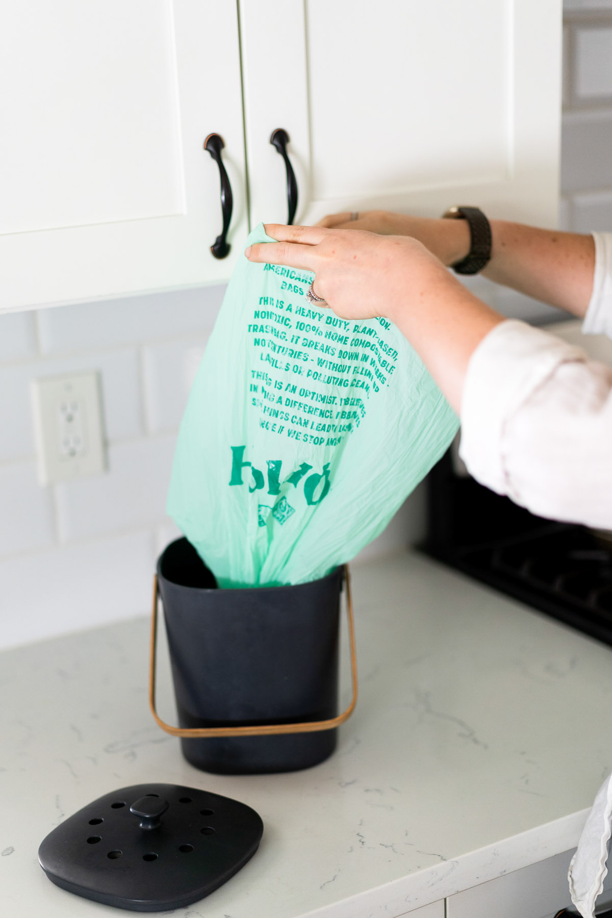 Placing compostable bag in compost pail