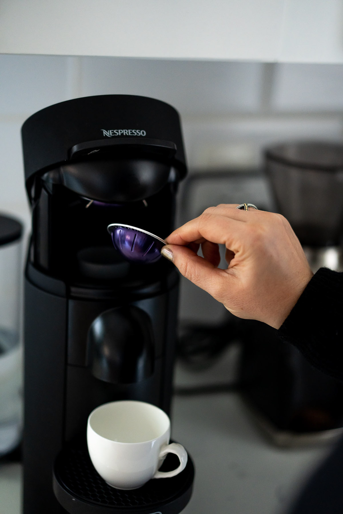 Nespresso Pod Going into Machine - Sustainable Coffee Companies