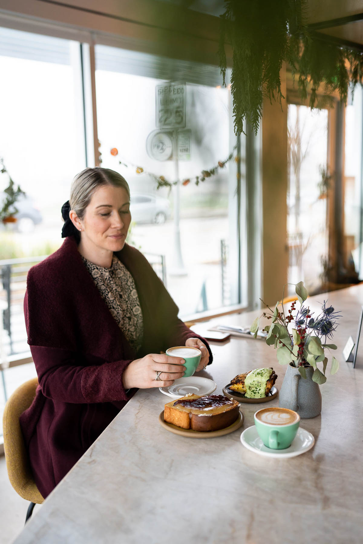 Luci Sitting at Counter with Coffee - Black TIghts Outfit - Fair Trade Dress