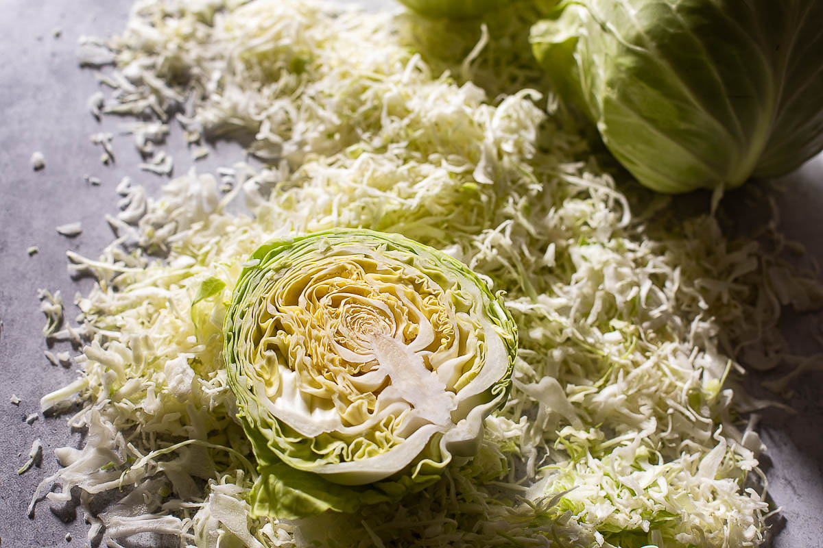 halved and shredded cabbage on table