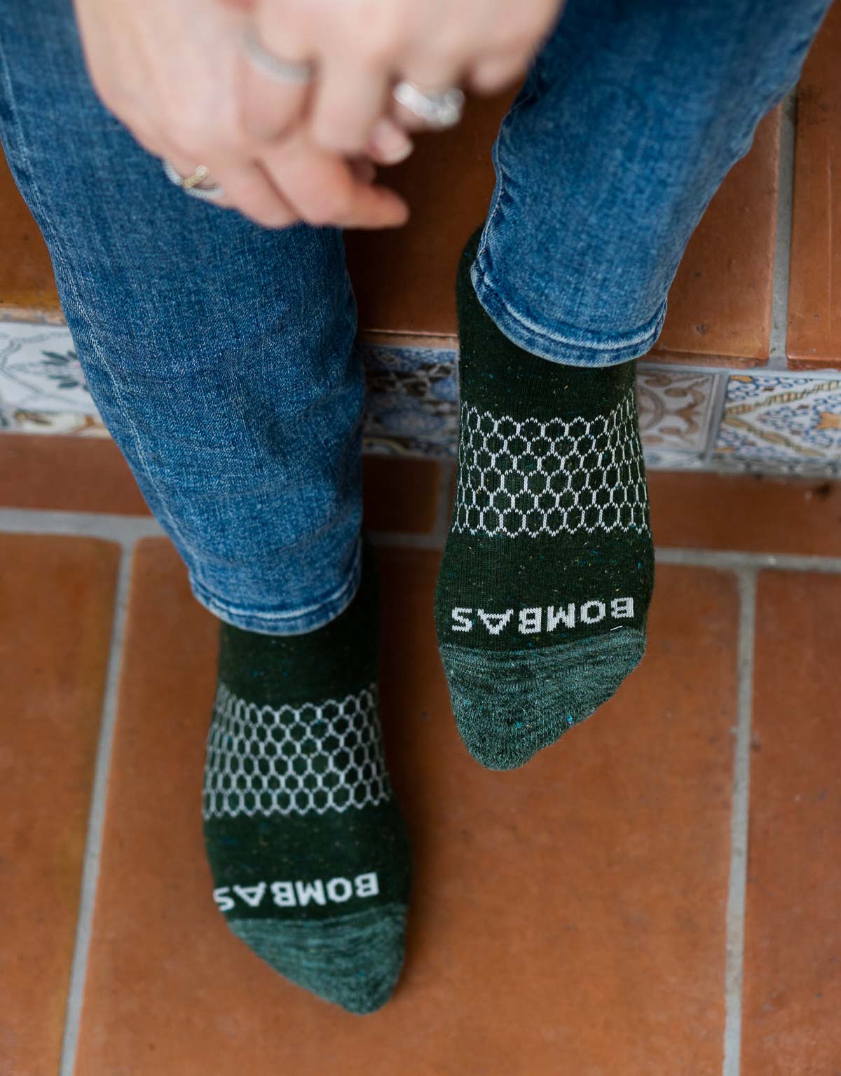 Sustainable Socks - Bombas socks - feet in green Bombas socks on Tile steps