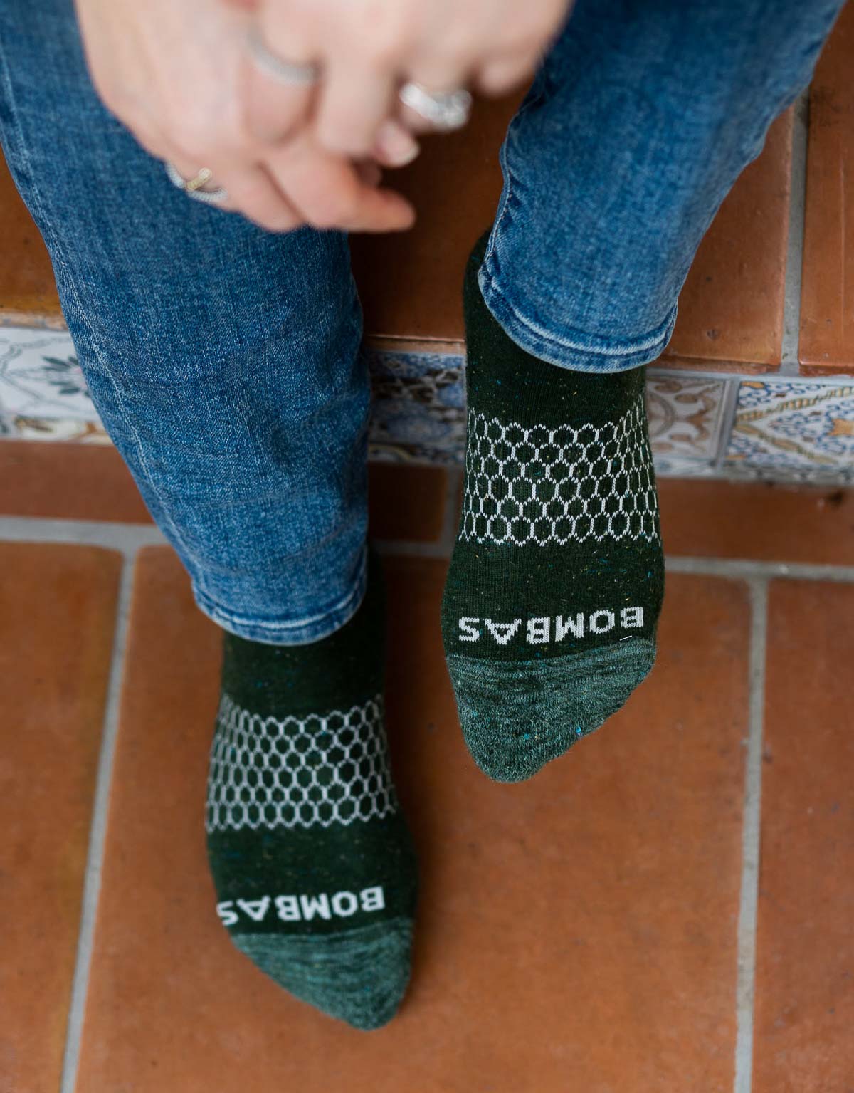 Sustainable Socks - Bombas socks - feet in green Bombas socks on Tile steps