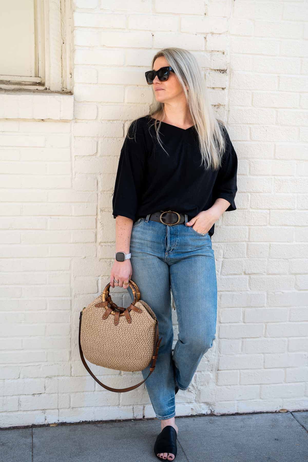 Outfit with Black top, sustainable jeans brand Outerknock, and slide black flats