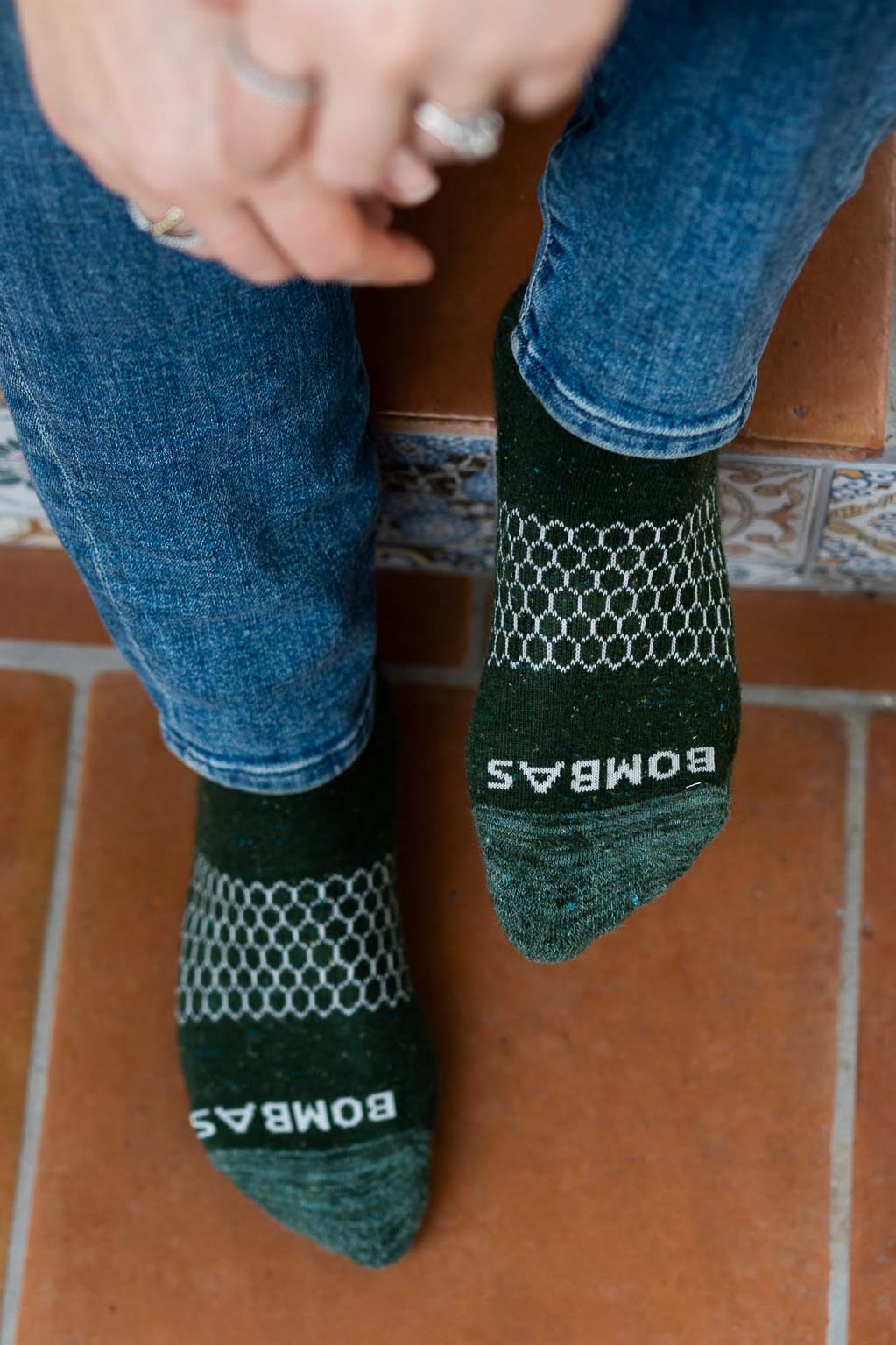 Sustainable Socks - Bombas socks - feet in green Bombas socks on Tile steps