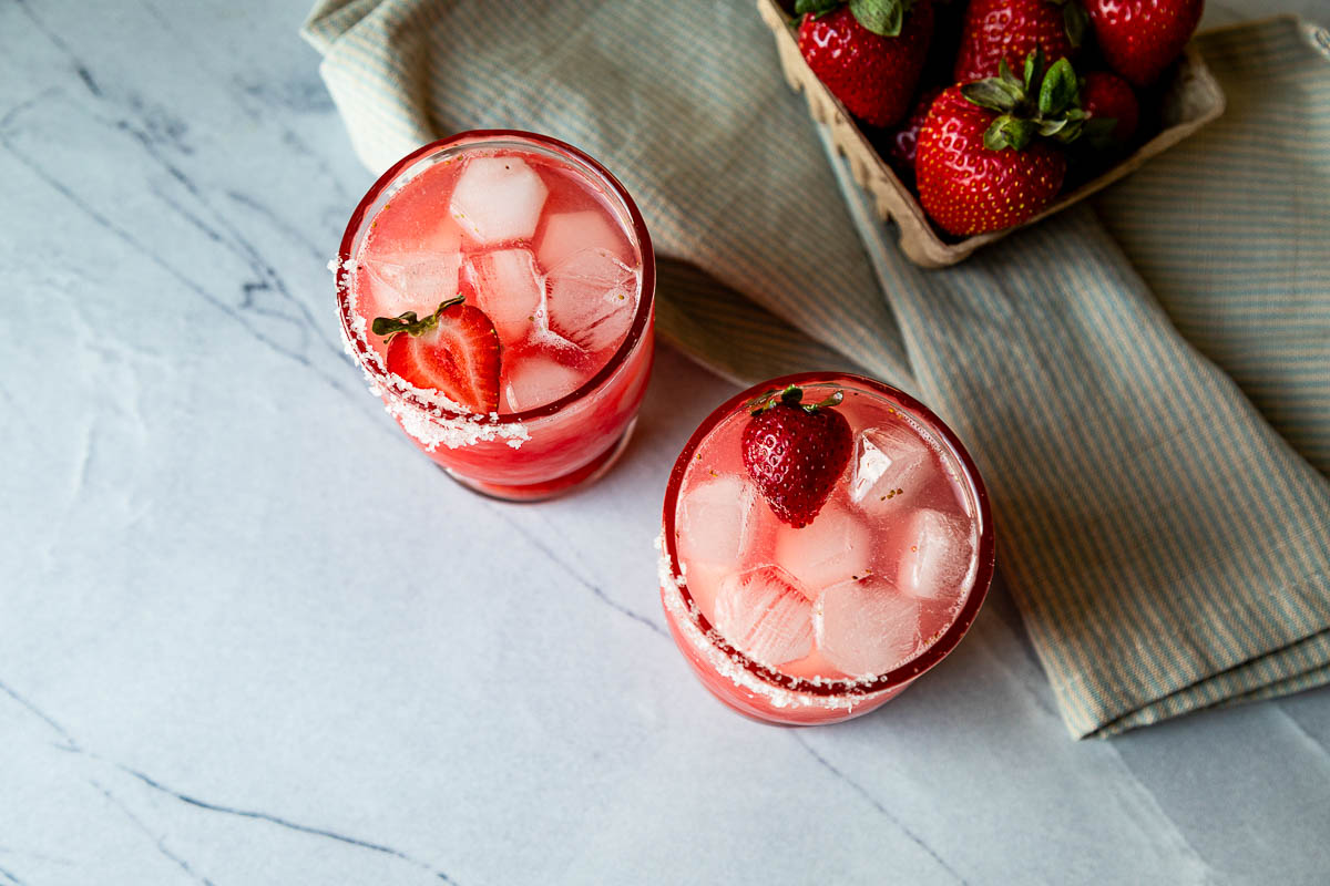 strawberry margarita on the rocks in 2 glasses - view form top of glasses