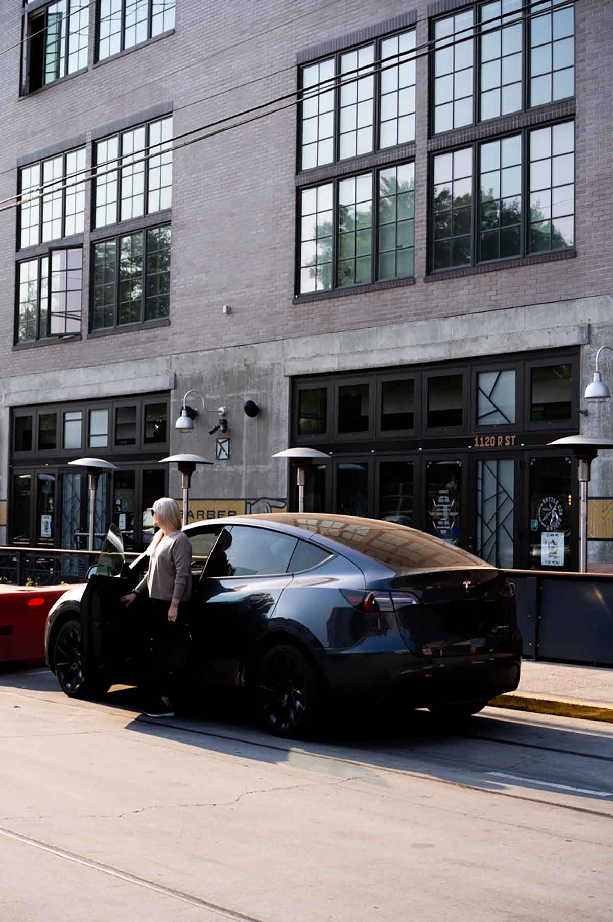 What to Keep In Your Car - luci standing by Tesla Model Y in Sacramento