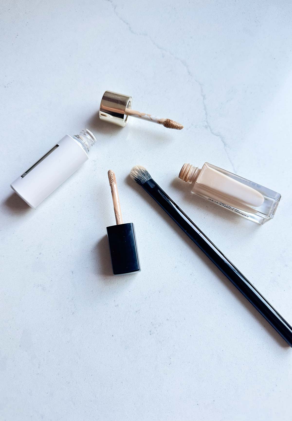 two concealers opened with doe foot applicators and brush nearby Best under eye concealer for mature skin 12
